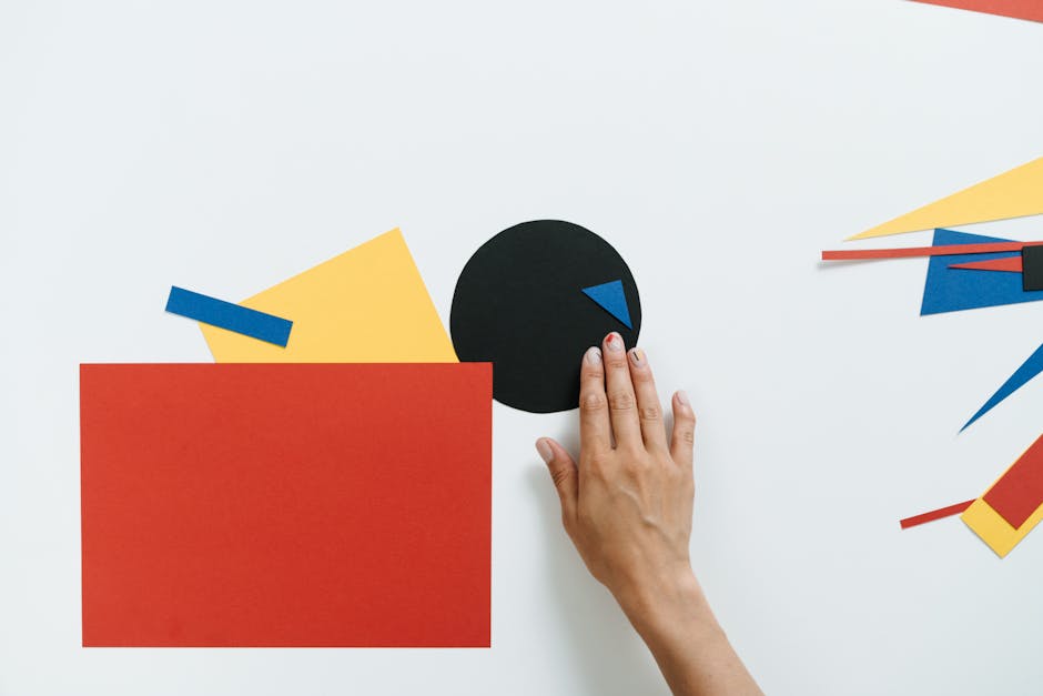 Contemporary artwork featuring geometric shapes in paper collage style with a hand interacting.