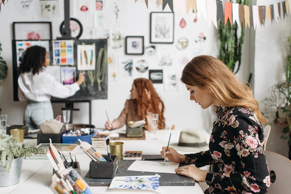 Women engaged in an art workshop with painting tools, creating art together in a studio setting.